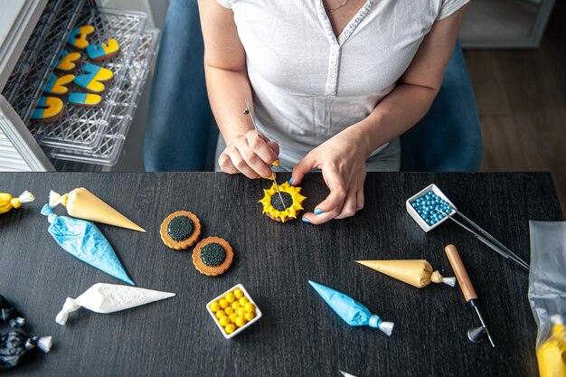 Woman confectioner making gingerbread sunflower gingerbread design