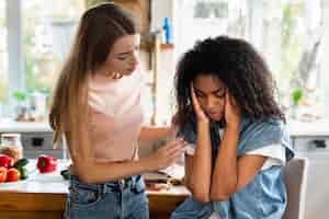 Free photo woman consoling her friend in the kitchen