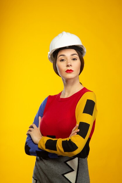 Woman in construction helmet poses on camera