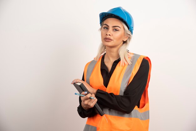 Woman construction worker standing with notebook. High quality photo