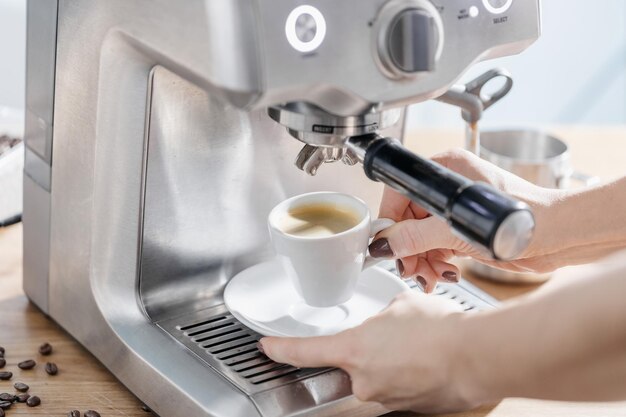 Woman cooking espresso with machine