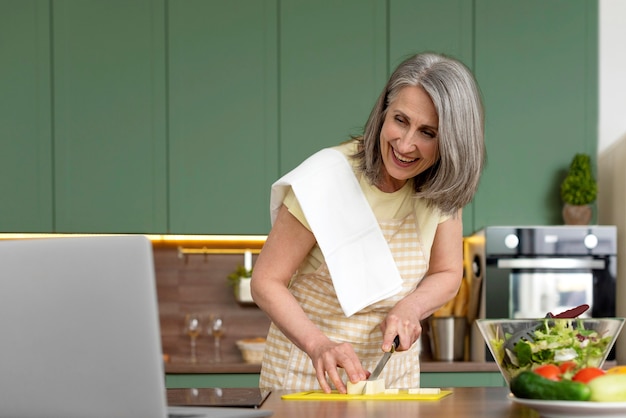 Woman cooking in a green kitchen