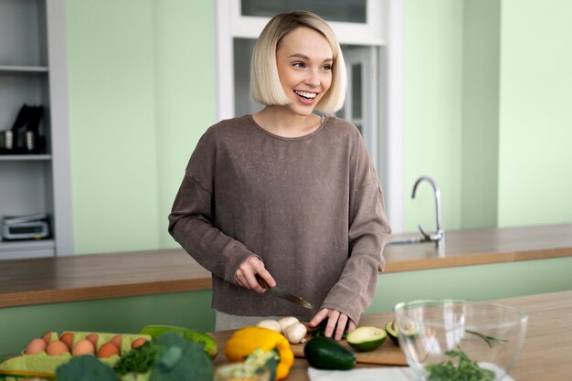 Woman cooking in a green kitchen