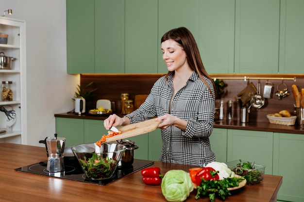 Бесплатное фото Женщина готовит на зеленой кухне