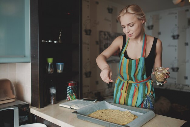 キッチンでピザを調理する女性
