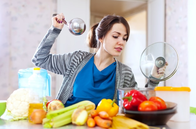 woman cooking veggie lunch with laddle