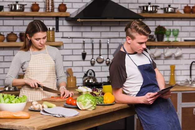 デジタルタブレットを使用している人ながら料理の女性