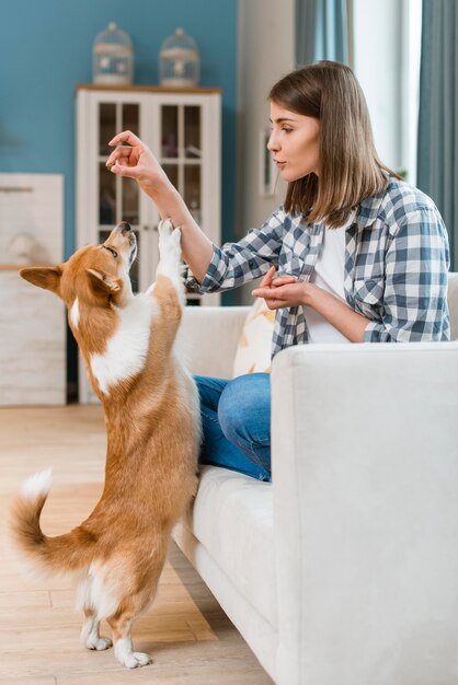 Woman on couch giving her dog a treat