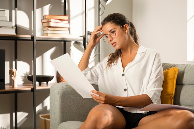 Woman on couch looking at paper