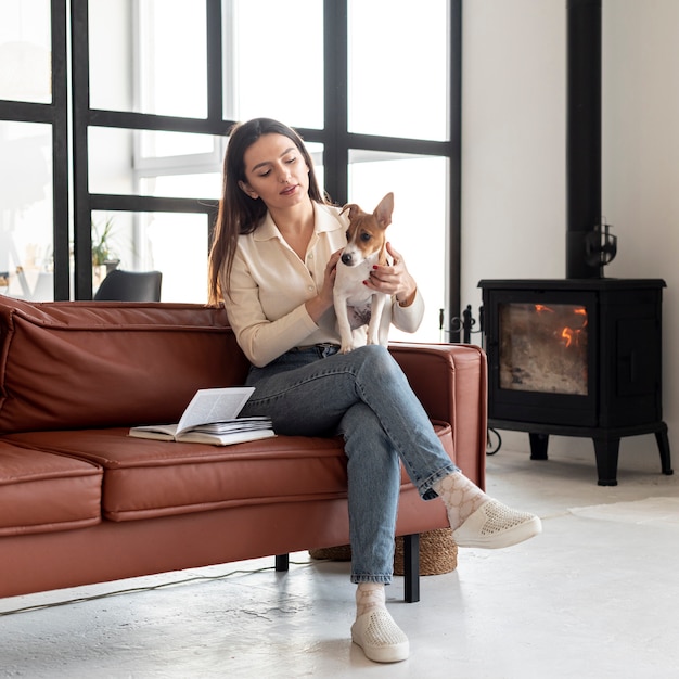 膝の上の彼女の犬と一緒にソファの上の女性