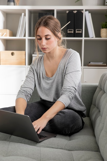 Foto gratuita donna sullo strato che lavora al computer portatile