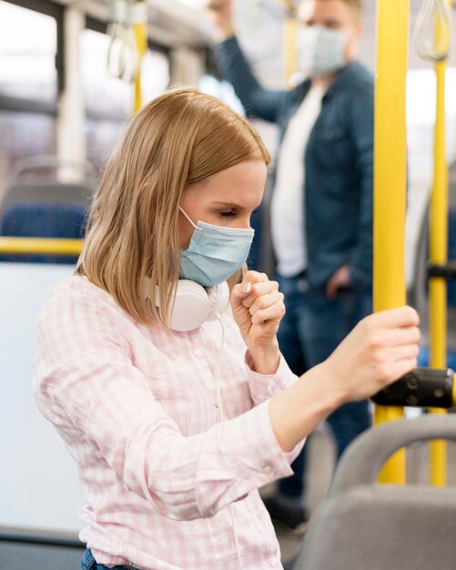 Женщина кашляет в автобусе с маской