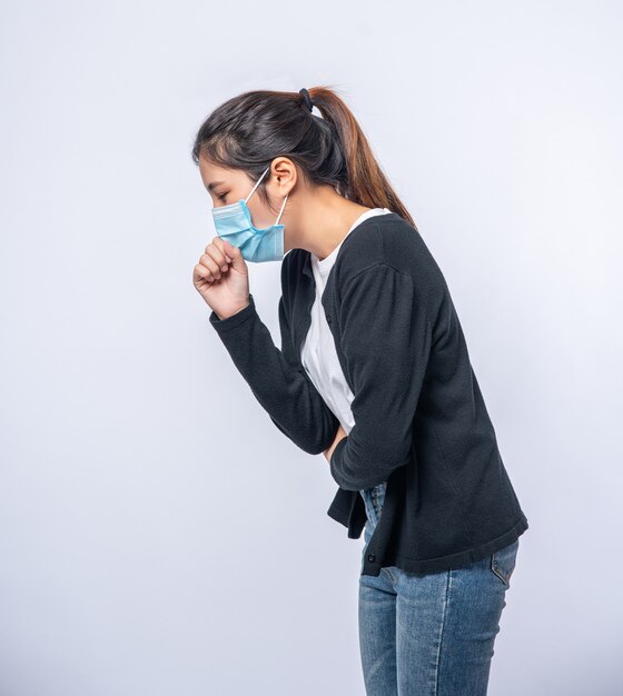 A woman coughing and covering her mouth with her hand