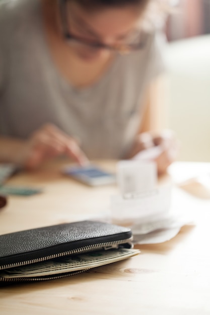 女性は彼女の電話でお金を数える