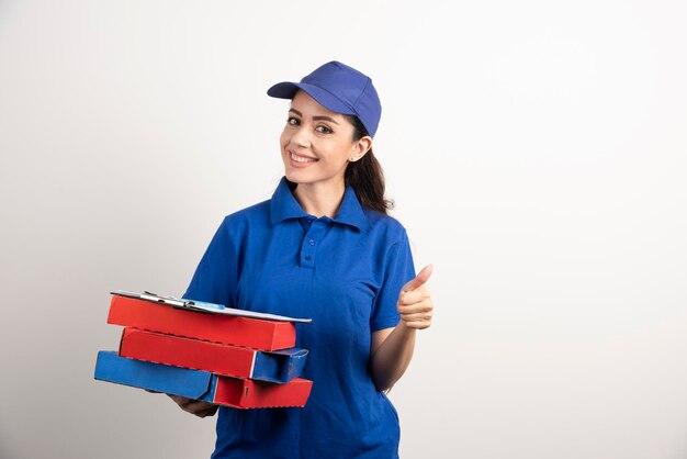 Woman courier with cardboard of pizza and clipboard . High quality photo