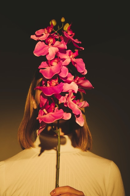 Woman covering face with flower 