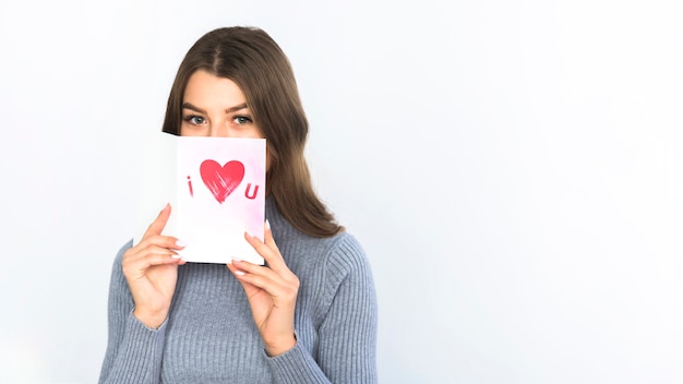 Woman covering face with greeting card 