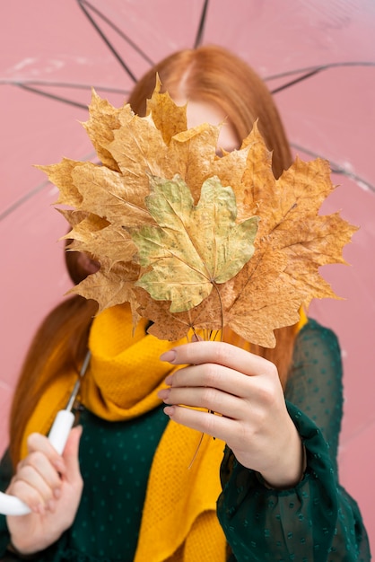 Woman covering face with leaves