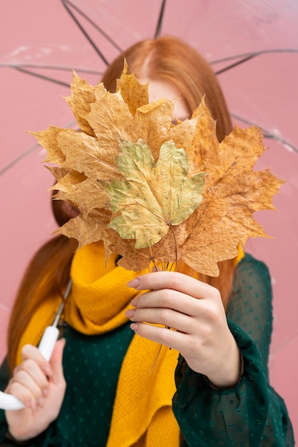Donna che copre il viso con foglie
