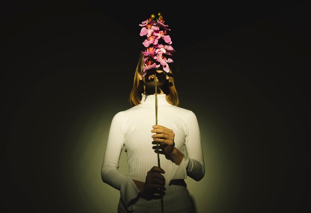 Woman covering face with pink flower 