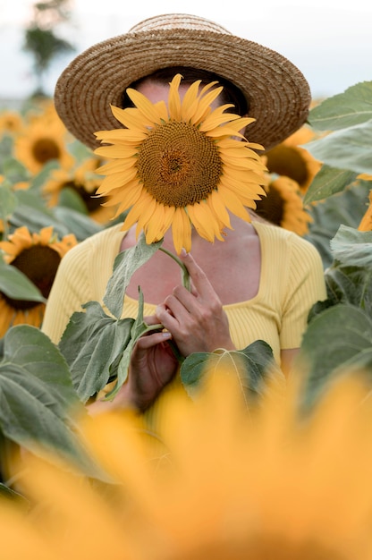 Woman covering face with sunflower