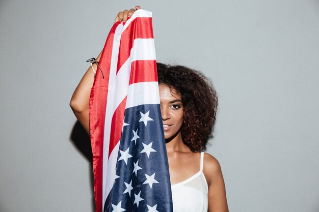 Woman covering half of her face with USA flag
