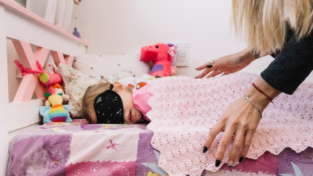 Free photo woman covering her daughter with woven scarf