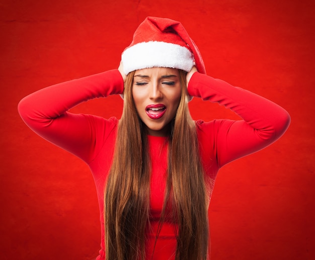 Foto gratuita la donna che copre le orecchie in uno sfondo rosso