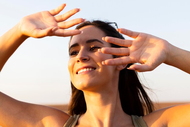 Woman covering her face from the sun while outdoors