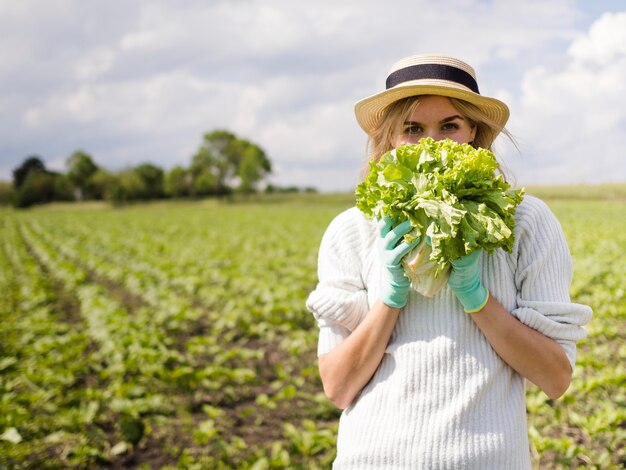 Woman covering her face with a cabbage