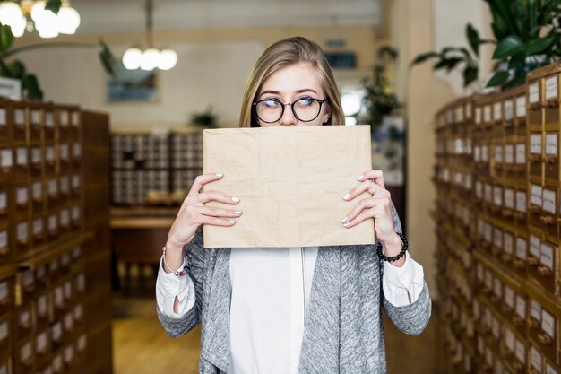 Woman covering mouth with book