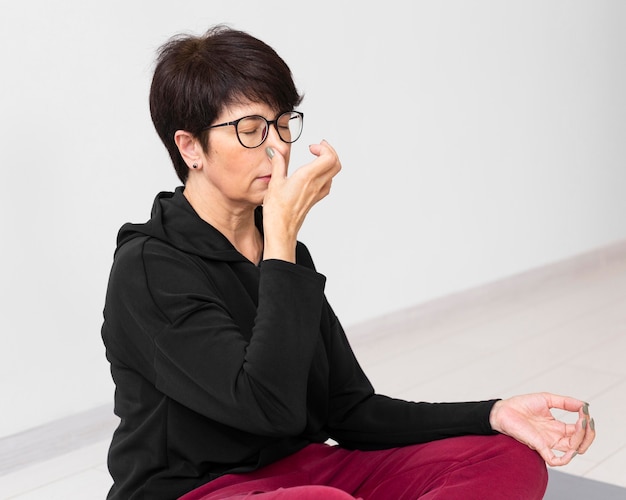 Woman covering a nostril while meditating