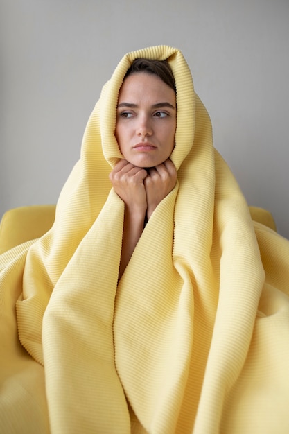 Free photo woman covering with blanket front view