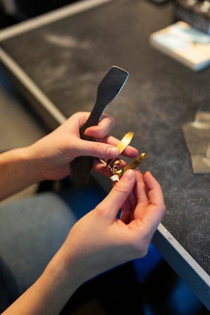 Free photo woman crafting a golden metallic object