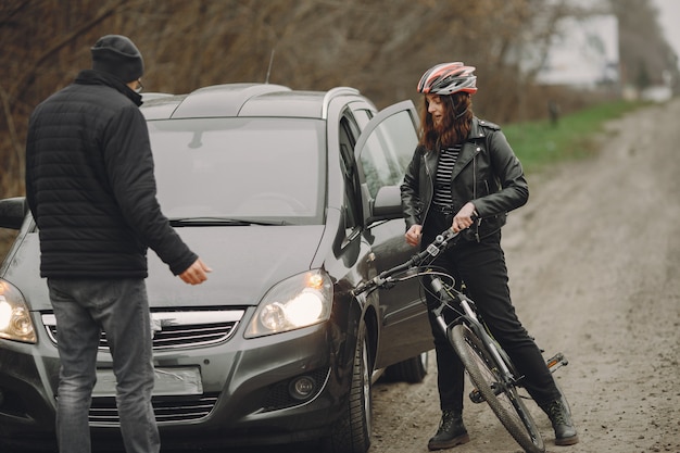 Foto gratuita la donna si è schiantata contro la macchina. ragazza in un casco. le persone litigano per l'incidente.