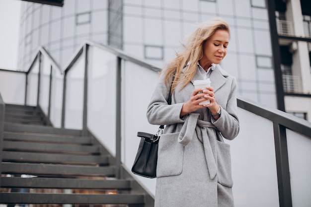 Woman crossing the bridge and drinking coffee