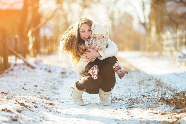 Woman crouching with her baby in her arms