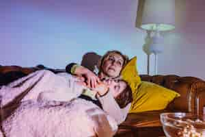 Free photo woman cuddling with daughter on couch