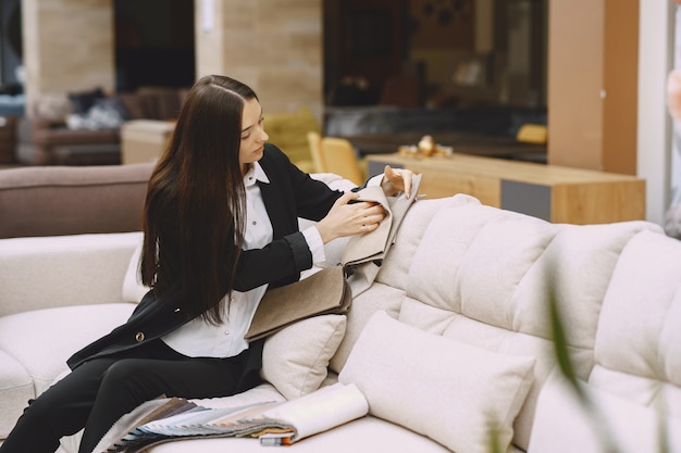 Cliente della donna che cerca bello tessuto nel negozio dei drappi