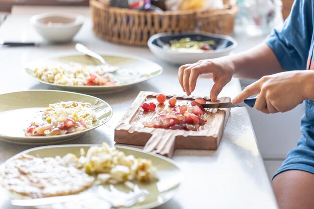 A woman cuts grapes on a cutting board