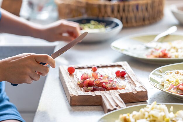 Free photo a woman cuts grapes on a cutting board