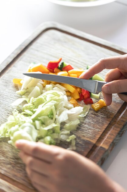 여자가 도마 위에서 야채를 자른다