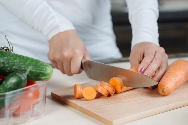 Woman cutting carrot