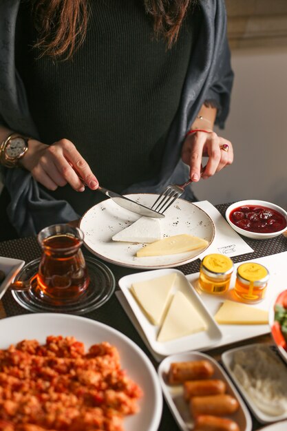 아침 식사를 위해 여자 절단 치즈 조각 제공