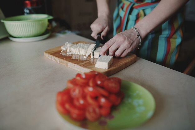 Женщина режет сыр