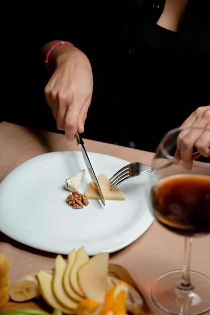 woman cutting parmesan cheese from the cheese plate