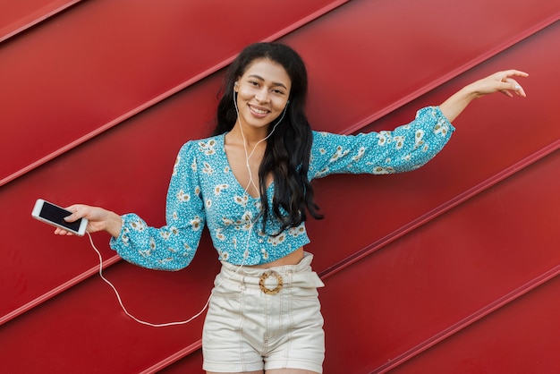 Woman dancing on music and looking at camera