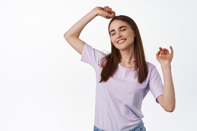 woman dancing and smiling, wearing purple t-shirt on white