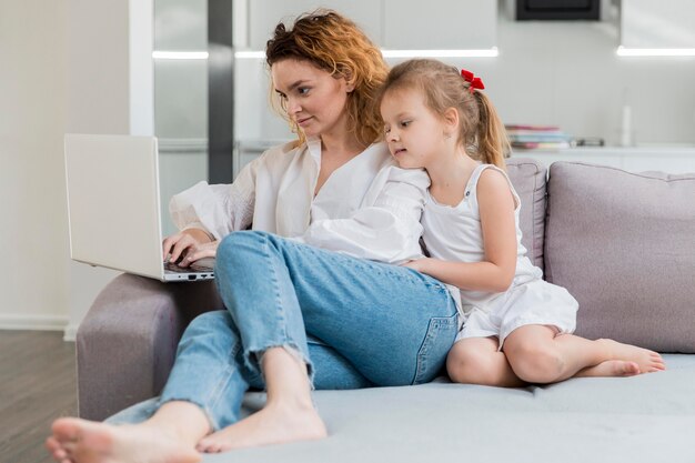 Woman and daughter sitting on couch