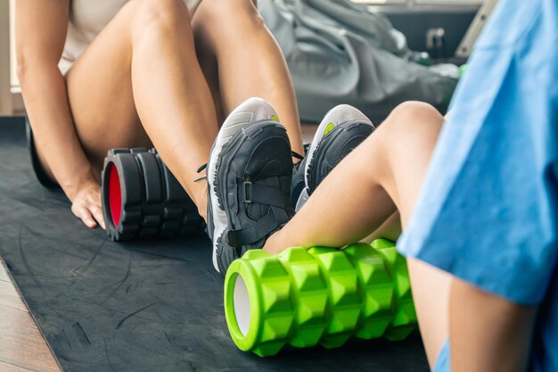 Free photo a woman and daughter a warm up exercise by putting a roller massager